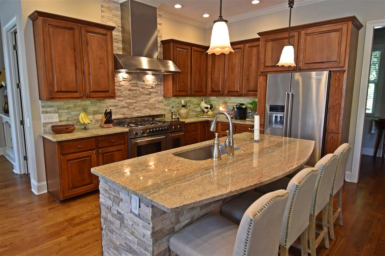 The very spacious Kitchen includes custom cabinetry, granite counters, large breakfast bar & island, stainless steel appliances, and overlooks the Breakfast & Hearth Rooms.
