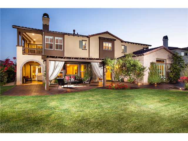 6989 Corte Langosta Carlsbad, CA 92009 - Photo 23 of 25 A view of the back of the home. The arched loggia on the left has french doors coming from the formal living room, has a travertine floor and a fireplace. The upper balcony is off of the master bedroom.