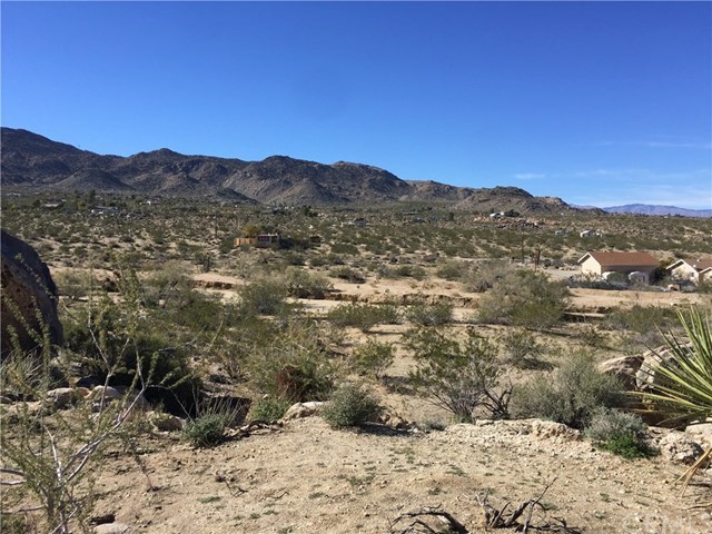 8140 Skyline Drive Joshua Tree, CA 92252 - Photo 22 of 27 The west view from hillside five acres. Paved Quail Springs Road is located at the houses.