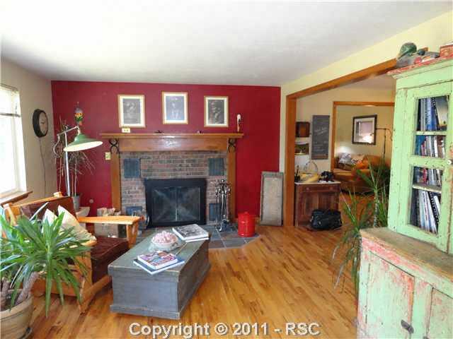 19150 Murphy Road Peyton, CO 80831 - Photo 4 of 16 Living room is off the dining room and features wood burning fireplace with heatilators. The wood floors are immaculate and add to the charm and beauty of this home.