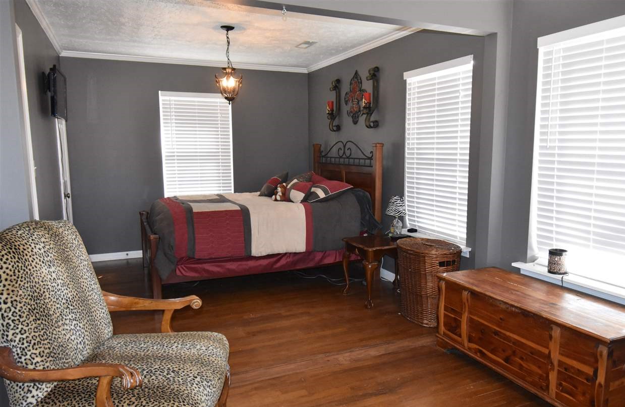1874 Walnut Grove Road Burlison, TN 38015 - Photo 13 of 24 Master Bedroom has chandelier, ceiling fan, hardwood floors and a half bath. The hall bath is just outside of the master bedroom and is all on one side of the home. It could all be a master suite.