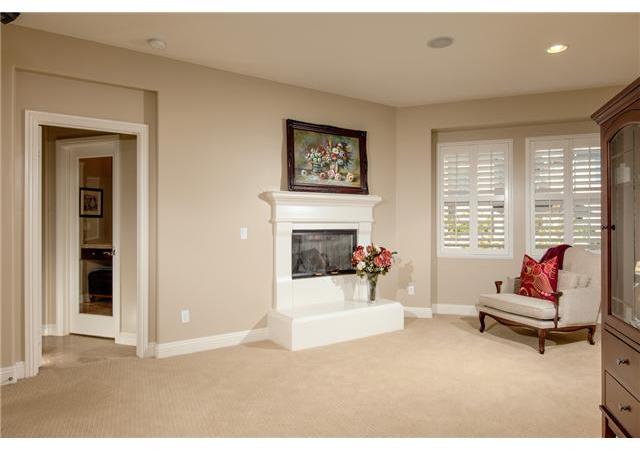6989 Corte Langosta Carlsbad, CA 92009 - Photo 14 of 25 Retreat in the master bedroom has a fireplace with a raised hearth and a french door to a covered outdoor balcony. Mirrored french door accessed one of two separate walk in closets and you can see the sit down vanity reflected in the mirror.