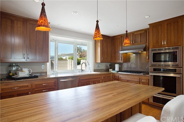 1588 Skyline Drive Laguna Beach, CA 92651 - Photo 7 of 18 Open chef's kitchen with pool and ocean views. Butcher block breakfast bar with high-end finishes and top of the line appliances, such as built-in Sub-Zero refrigerator, Viking cooktop and Thermador oven. Cherry wood cabinets.