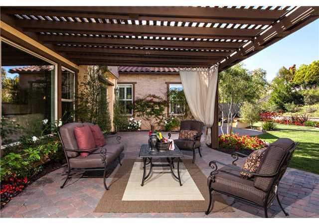 6989 Corte Langosta Carlsbad, CA 92009 - Photo 22 of 25 Rear yard with meandering paver stone patios including this cozy covered space.