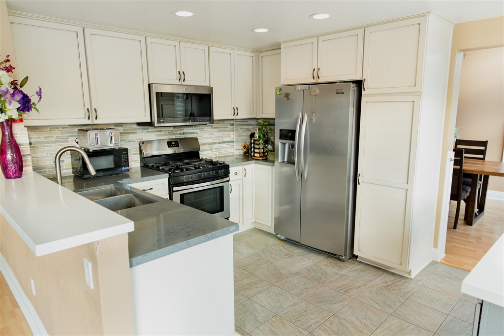 2105 Madiera Drive Oceanside, CA 92056 - Photo 19 of 25 Enjoy making a delicious dinner in this bright and modern, recently renovated kitchen, featuring upgraded new kitchen cabinets, quartz countertops, recessed lighting, tile floors and a matching kitchen island that is easy to move.