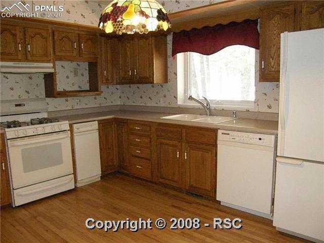 11910 Windmill Road Colorado Springs, CO 80908 - Photo 11 of 14 Country Kitchen w/Hardwood Floors, Built-In Desk, Gas Range & 2 Sets of Pantries