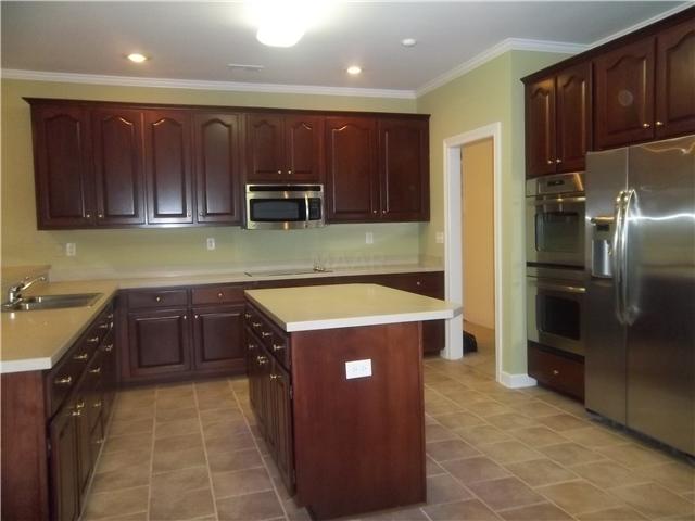 Newly remodeled kitchen with brand new stainless steel applicances, Corian countertops, tile floor, and breakfast bar.  Under cabinet lighting adds to the ambiance of this wonderful kitchen.