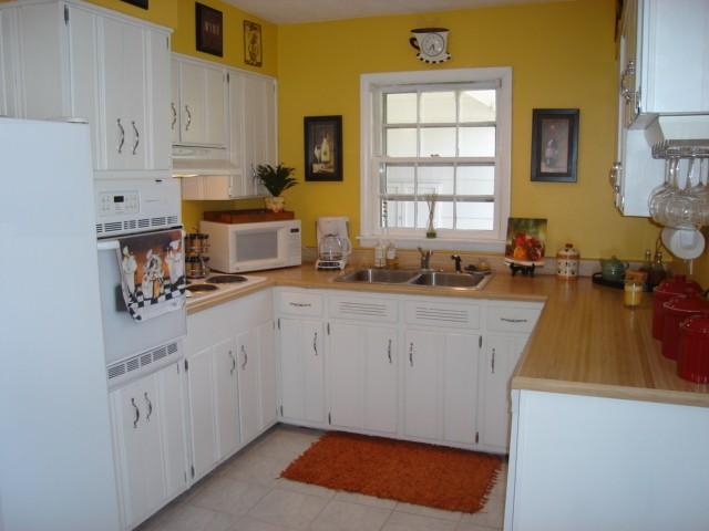 302 North Yates Road Memphis, TN 38120 - Photo 4 of 9 Updated Kitchen with Fresh White Cabinets, Tile Floor, Self-Cleaning Oven, Dishwasher, Disposal, Recessed Light, and Breakfast Area with Windows Overlooking Brick Patio in Rear Yard.