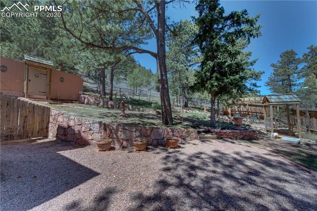 7955 Highway 24 Cascade, CO 80809 - Photo 36 of 36 Property offers a myriad of entertaining spaces including a pergola next to a waterfall and small pond.