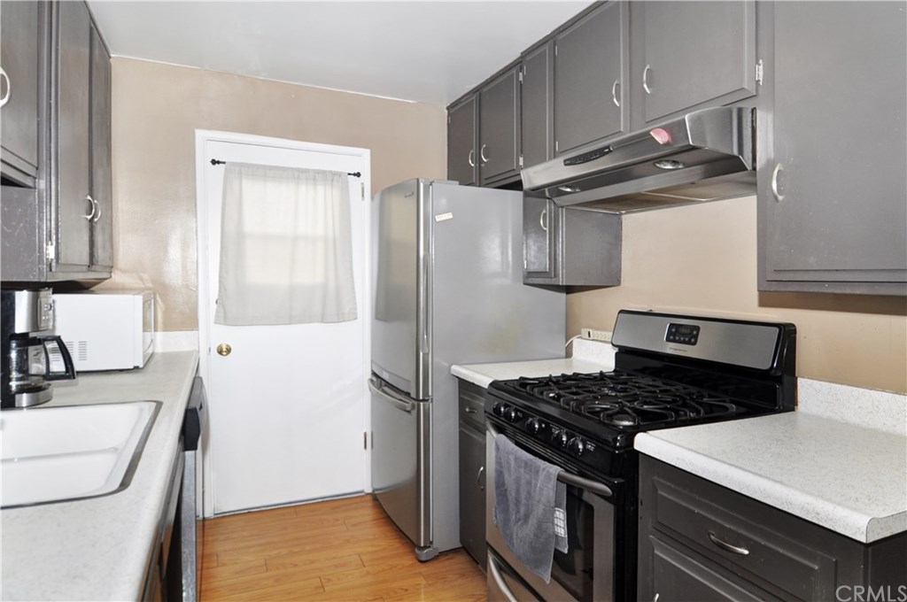 253 17th Street Seal Beach, CA 90740 - Photo 18 of 36 Coordinated silver appliances, laminate flooring and a side kitchen door.