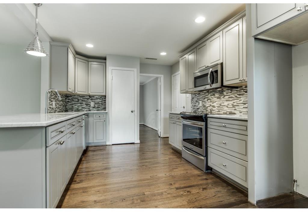 Warm hardwoods, gleaming Carrara marble counter tops, and all new cabinets complement this expanded kitchen. 