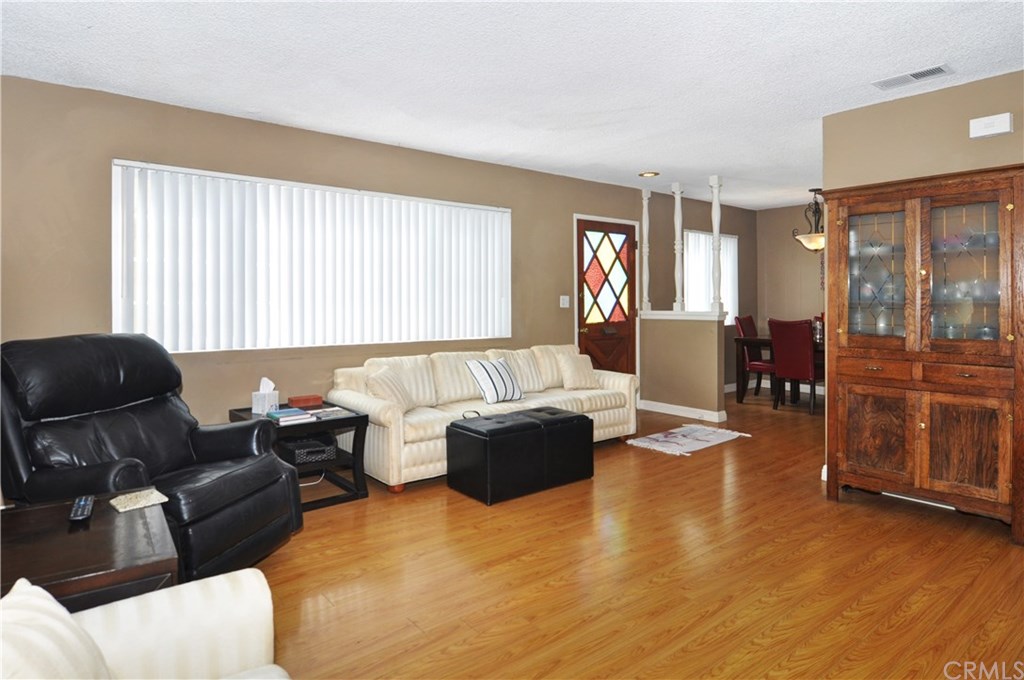 253 17th Street Seal Beach, CA 90740 - Photo 22 of 36 A great picture of the living room, dining area and elegant colored glass front door.