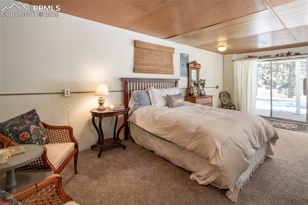 8715 Chipita Park Road Cascade, CO 80809 - Photo 30 of 33 Sliding glass door and large glass windows in the 3rd bedroom looking out to the front of the home.