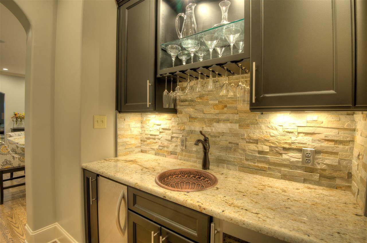 1277 South Dubray Place Collierville, TN 38017 - Photo 5 of 25 The custom built refreshment center offers a hand hammered copper sink, ice maker, wine reserve, granite top, stone back splash, glass shelves designed to hold your glassware!