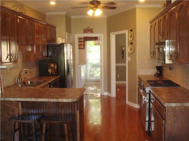 A gourmet cooks's delight, this kitchen features staiinless apppliances, a gas cook top eating bar, and pantry.  Beautiful hardwood floors.
