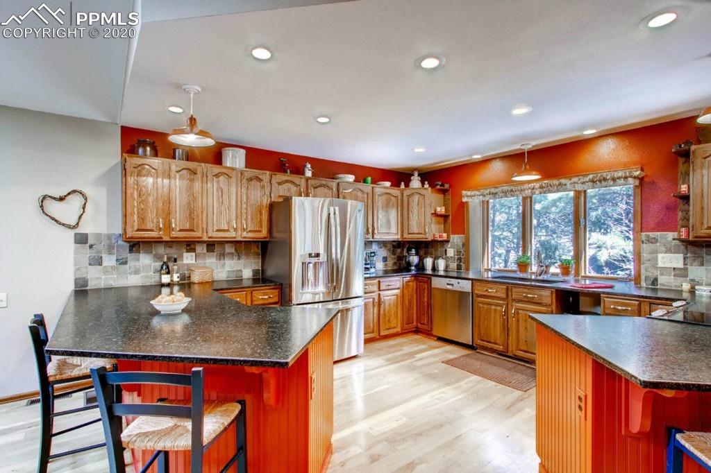 3210 Arena Road Colorado Springs, CO 80921 - Photo 9 of 30 Beautiful large newly updated kitchen with granite slab counters, high-end appliances, breakfast bar, and hardwood floors. A gourmet's delight!