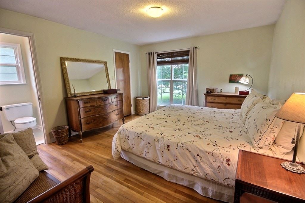 285 Poplar Acres Road Piperton, TN 38017 - Photo 12 of 21 The master bedroom with its hardwood floors has a walk in closet, renovated bath with newly tiled shower & seamless shower door, tile floors, granite countertop, light fixtures and vanity mirror.