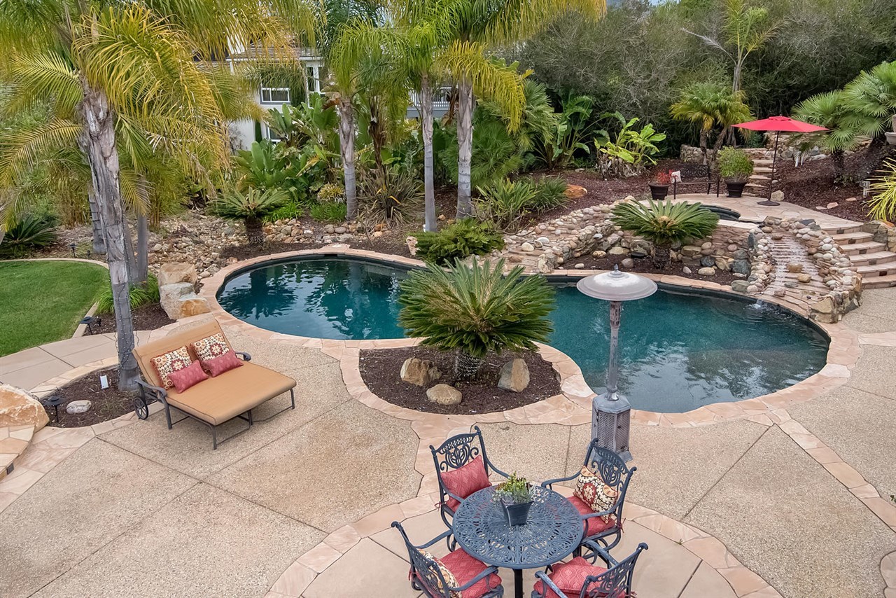 512 Latigo Row Encinitas, CA 92024 - Photo 21 of 25 The backyard oasis has several patios, fire pit, pool and spa with a tropical waterfall.