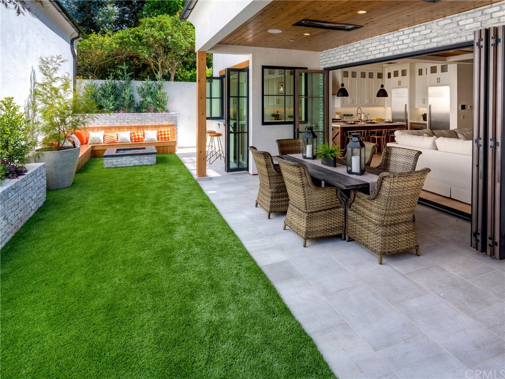 559 31st Street Manhattan Beach, CA 90266 - Photo 12 of 49 Private backyard, fire pit with seating, low maintenance artificial turf, covered patio with built-in heaters, sandblasted marble floor tiling, LaCantina door systems for the perfect indoor/outdoor experience, surround sound.
