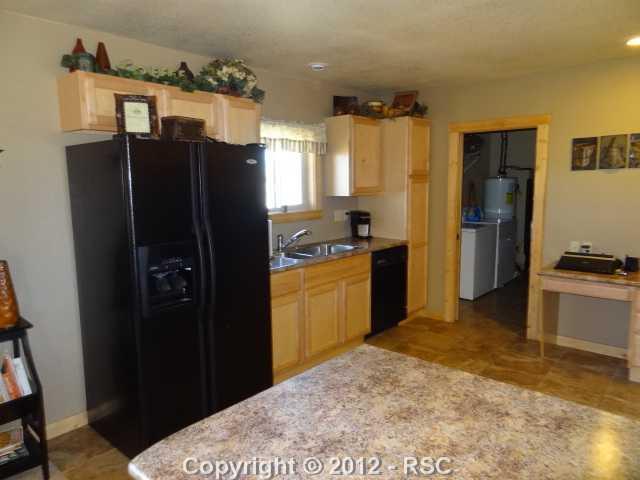 29 Ridge Point Circle Divide, CO 80814 - Photo 6 of 16 New kitchen with maple cabinets, granite look countertops, newer black appliances, and ceramic tiled floors.