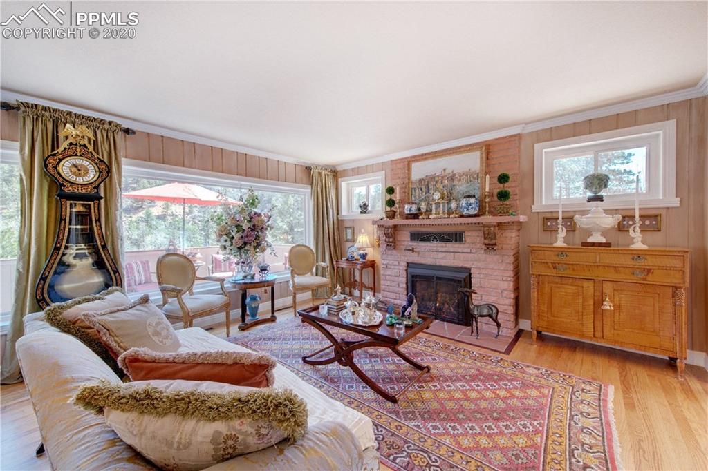 7955 Highway 24 Cascade, CO 80809 - Photo 6 of 36 Main-level living room is warmed by a Heatilator fireplace framed in Lyons flagstone.