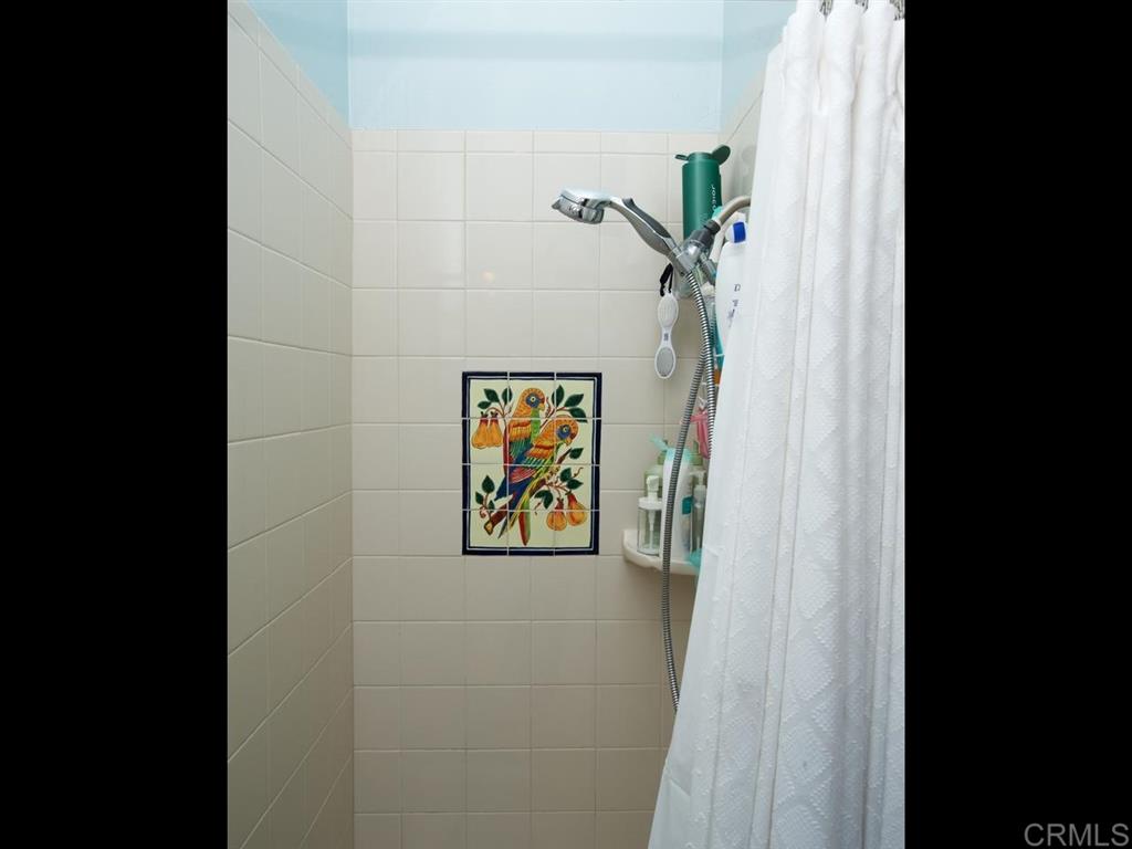 869 Beryl Street San Diego, CA 92109 - Photo 14 of 25 3/4 bathroom located in the hallway of the upstairs unit has walk-in shower with custom tile surround.