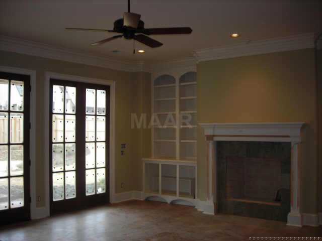 7344 McVay Road Germantown, TN 38138 - Photo 5 of 7 Living Room w/VentlessFP Framed by Custom Cabinets. Wall of Windows & Glass Door that Opens to Patio & Lush Rear Yard w/Shadowbox Fence.