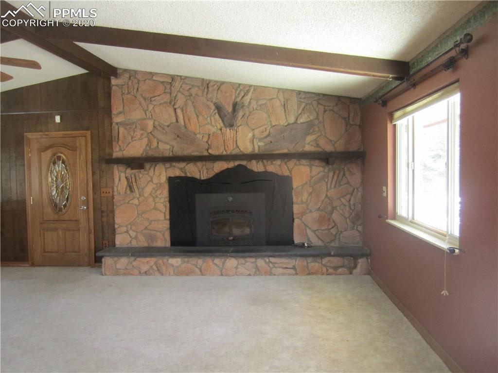 23455 Murphy Road Calhan, CO 80808 - Photo 2 of 35 Great room with vaulted ceiling, wood beams, wood burning fireplace
