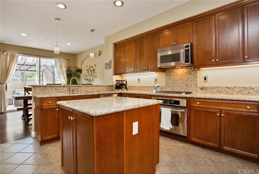 21 Corte Javier San Clemente, CA 92673 - Photo 3 of 30 Recessed LED lighting and crystal drop lights brighten the cheery kitchen.