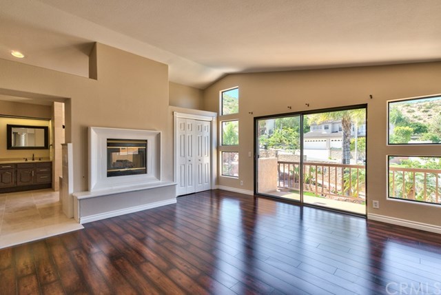 3086 Diamondview Circle Corona, CA 92882 - Photo 15 of 66 Encompassing the entire upstairs rear wing, the sumptuous master suite pampers with a dual-sided fireplace between the bedroom and the master bath, a private balcony with mountain views and an adjoining retreat that will adjust to your lifestyle