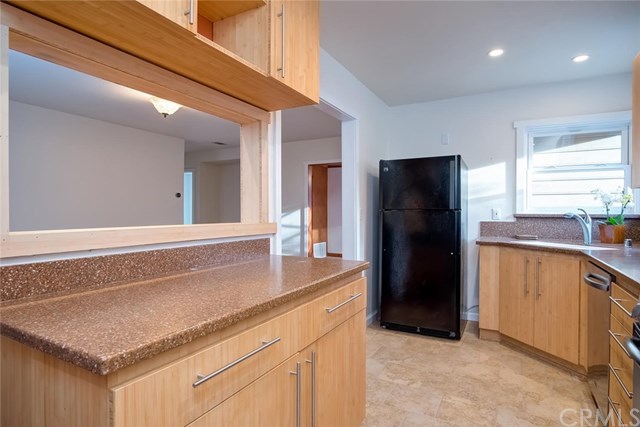 34096 El Contento Dana Point, CA 92629 - Photo 17 of 43 Open access to living room from the remodeled kitchen with custom bamboo cabinetry, stainless steel appliances, recessed lighting and corian counter tops.*Download 4 page Features list PDF for more details.