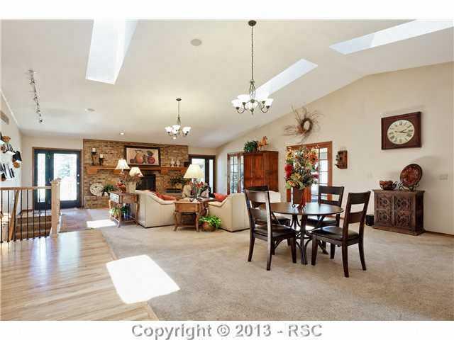 14575 Raton Road Colorado Springs, CO 80921 - Photo 7 of 25 Great Room on main level has french doors that open into the pool area. 2 walkouts to the Huge Deck in back. Plenty of space for multiple seatting areas, Gas fireplace for cold winter nights.