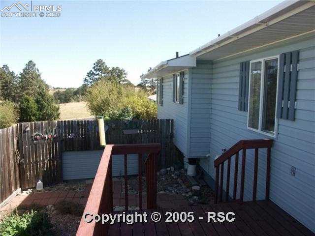 17874 Pinon Park Road Peyton, CO 80831 - Photo 3 of 7 Fenced backyard with deck