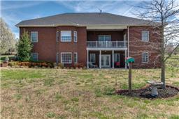 REAR OF HOME OVERLOOKING ROLLING ACRES WITH COVERED PATIO 