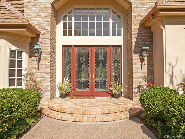 Bathed in natural light the two story entry is artfully trimmed with magnificent leaded glass doors.