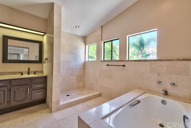 3086 Diamondview Circle Corona, CA 92882 - Photo 16 of 66 The sumptuous master bath features an oval tub and separate shower with extensive use of stone, re-stained cabinetry, new framed mirrors and new faucets.