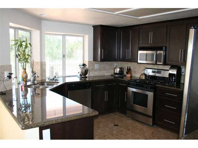 1471 Green Oak Road Vista, CA 92081 - Photo 3 of 19 Another view of the stylish kitchen, notice the garden window, tile floors with coordinating granite insets. Tumbled stone back splash adds custom flair!