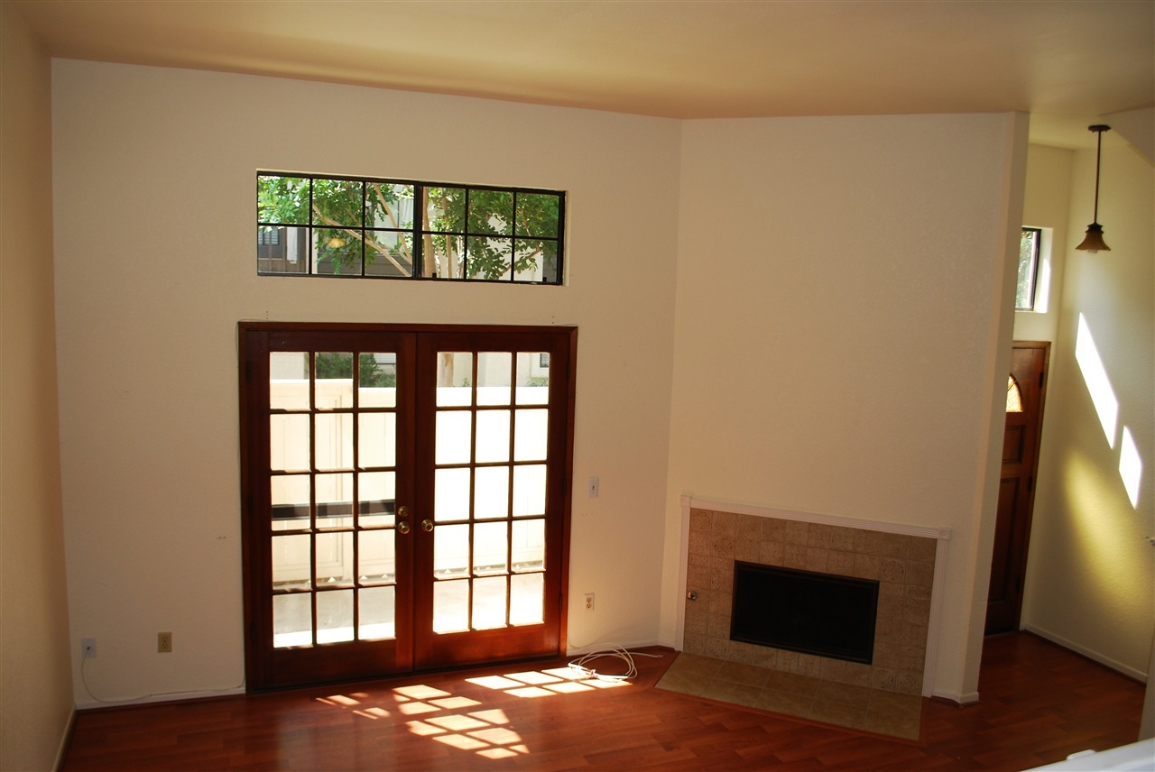 Living room through french doors to fenced patio