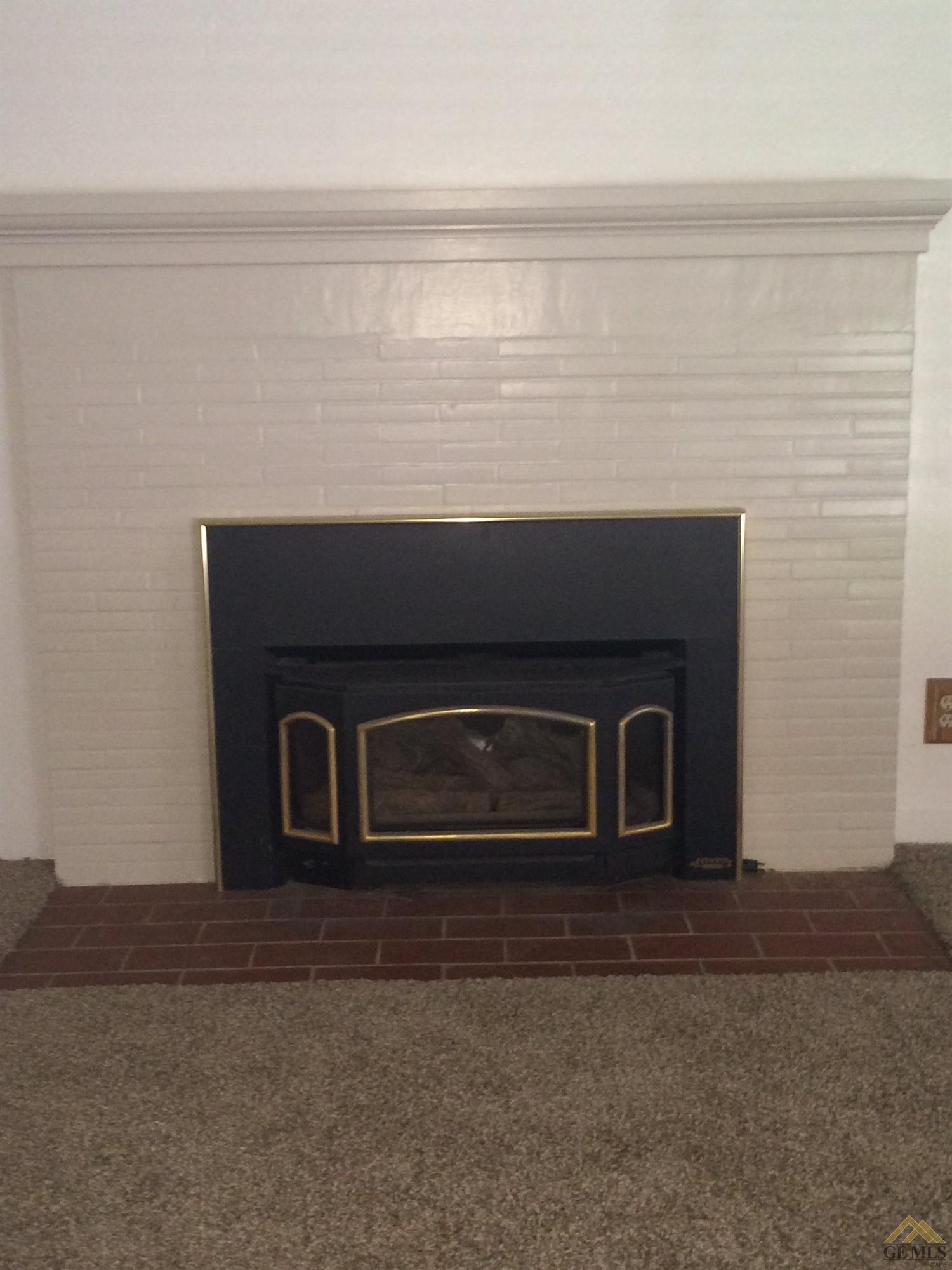 1733 Locust Ravine Bakersfield, CA 93306 - Photo 14 of 33 Gas fireplace insert and tiled surround and mantle.