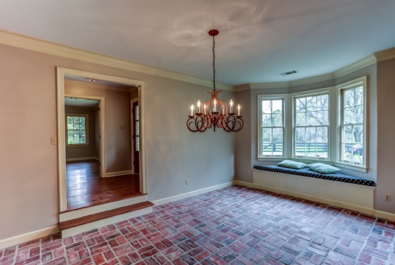 12206 Monterey Road Collierville, TN 38017 - Photo 5 of 25 Step down into the versatile dining or living room accentuated by a brick floor, chandelier lighting, & bayed window seat.