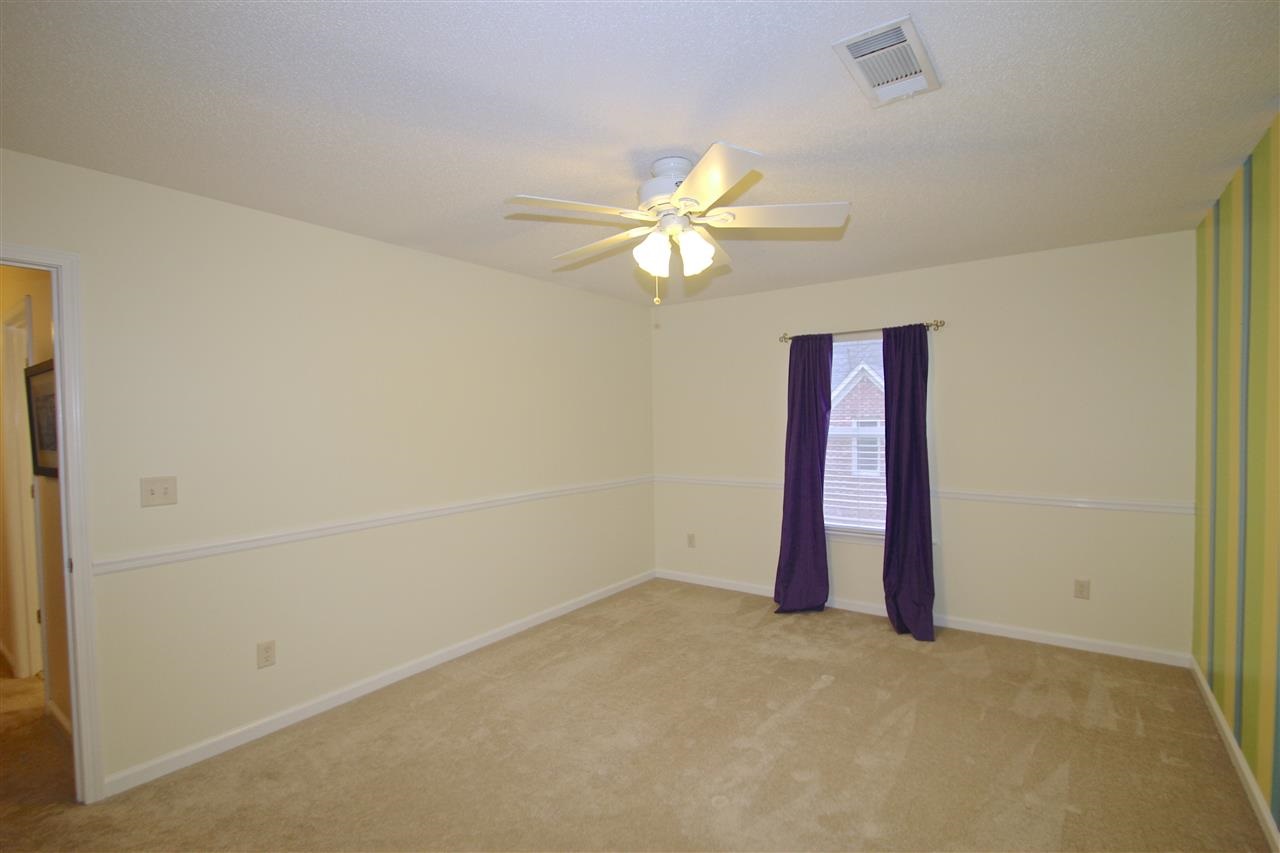 4371 High Plains Road Bartlett, TN 38135 - Photo 17 of 25 Terrific third bedroom features a soothing ceiling fan, chair rail, walk-in closet, neutral colors and a striped colored accent wall.