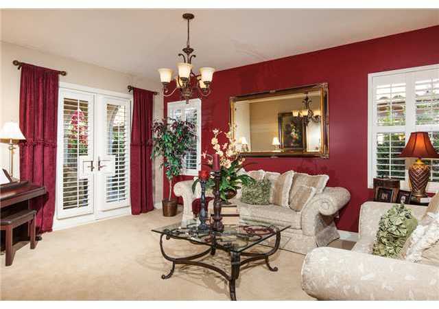 6989 Corte Langosta Carlsbad, CA 92009 - Photo 7 of 25 Formal living room/music room has french doors with plantation shutters to a covered loggia with a fireplace.