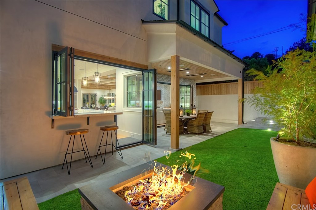 559 31st Street Manhattan Beach, CA 90266 - Photo 13 of 49 Private backyard, fire pit with seating, low maintenance artificial turf, covered patio with built-in heaters, sandblasted marble floor tiling, LaCantina door systems for the perfect indoor/outdoor experience, surround sound.