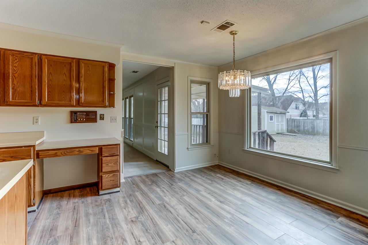 8471 Bazemore Road Memphis, TN 38018 - Photo 11 of 25 NEW wood laminate floor, crown molding, chair rail and large picture and 2 additional windows with views of back yard.