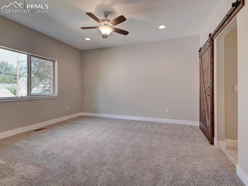 208 Custer Avenue Colorado Springs, CO 80903 - Photo 14 of 36 Main level bedroom with custom knotty alder barn door and industrial track!