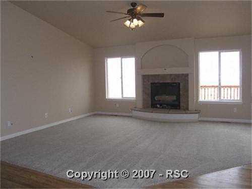 9498 Rockingham Drive Peyton, CO 80831 - Photo 7 of 15 Spacious vaulted great room with tile gas fireplace with raised hearth with hearthstones.