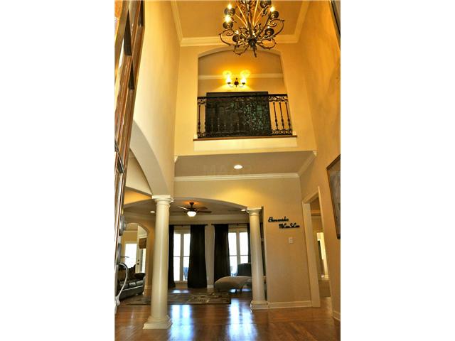 This home boasts an impressive 2 story foyer which includes hardwood floors, chandelier, and a beautiful wrought iron balcony above.
