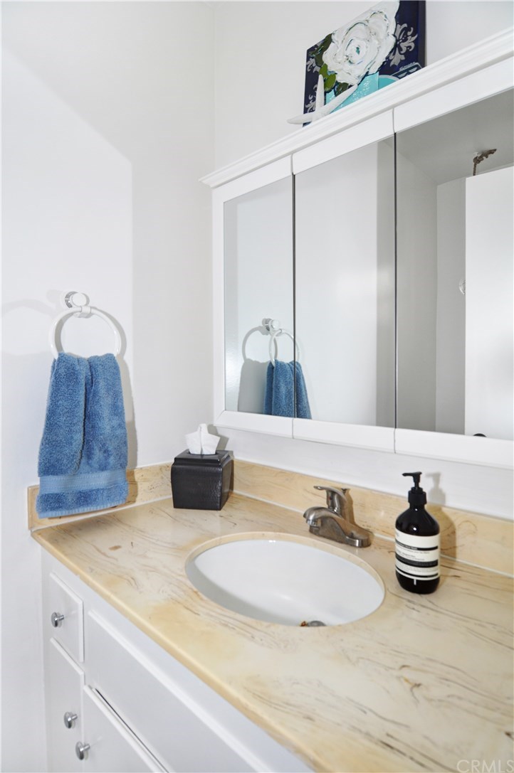 253 17th Street Seal Beach, CA 90740 - Photo 11 of 36 Downstairs, guest half bath with a sink and adjacent toilet