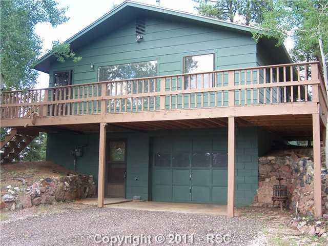 2126 Upper Twin Rocks Road Florissant, CO 80816 - Photo 2 of 14 Paved Asphalt Driveway and Extended Parkng Area Leads Into Drive-Under Oversized One Car Garage With Shop and Walk-In to Lower Level of Home.