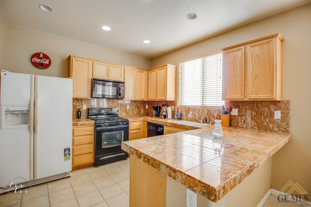 5409 Ridgecrest Court Bakersfield, CA 93313 - Photo 11 of 24 Kitchen with granite tile counter top, oak cabinets with appliances